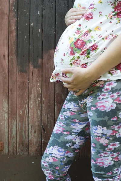 Έγκυος γυναίκα μπροστά από το ξύλινο τείχος — Φωτογραφία Αρχείου