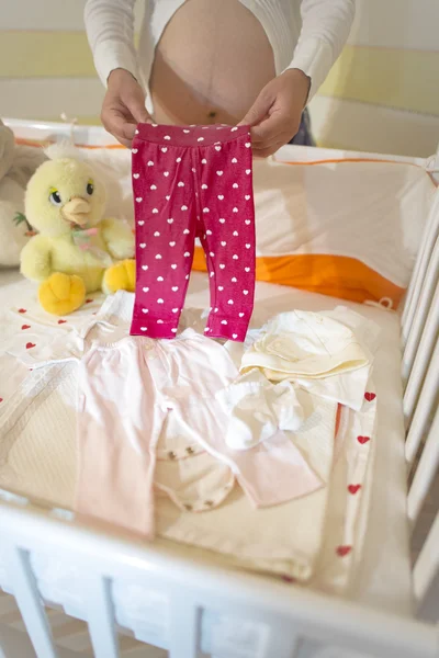 Беременная женщина в детской комнате — стоковое фото