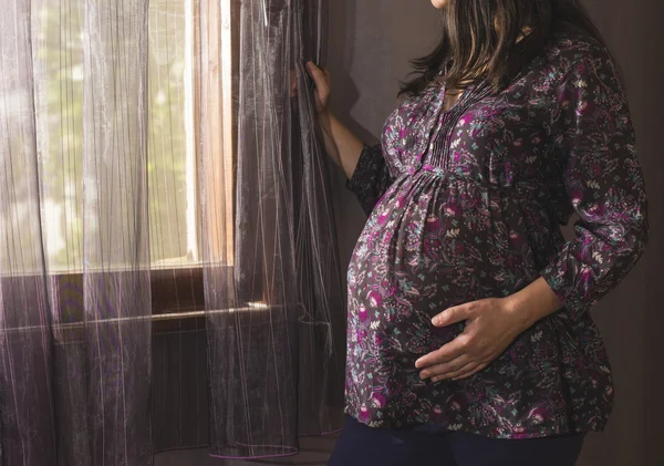 Mujer embarazada cerca de la ventana —  Fotos de Stock