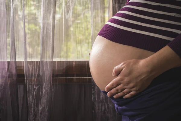 Zwangere vrouw in de buurt van venster — Stockfoto