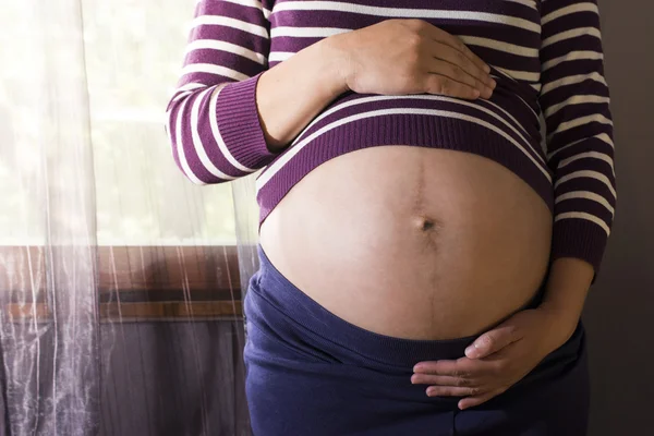 Mulher grávida perto da janela — Fotografia de Stock