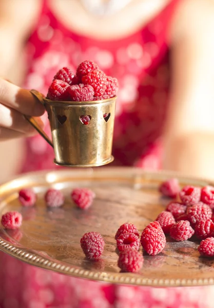 Frau mit Tasse Himbeeren — Stockfoto