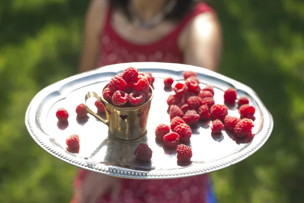 Frau mit Tasse Himbeeren — Stockfoto