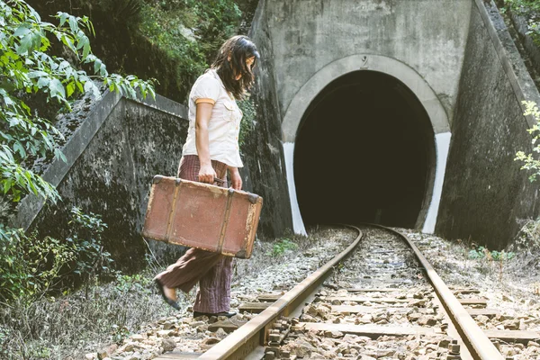 Femme marchant sur le chemin de fer avec valise — Photo