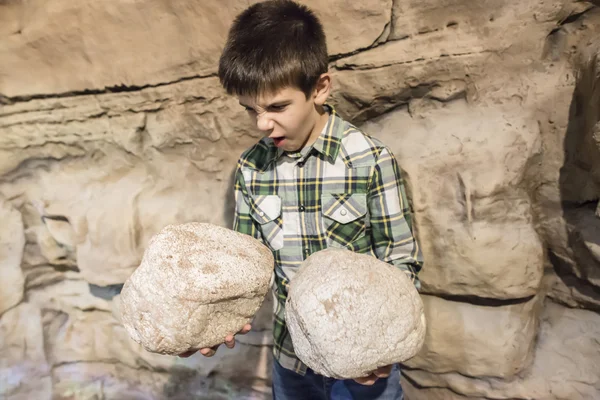 Niño sosteniendo piedras pesadas — Foto de Stock