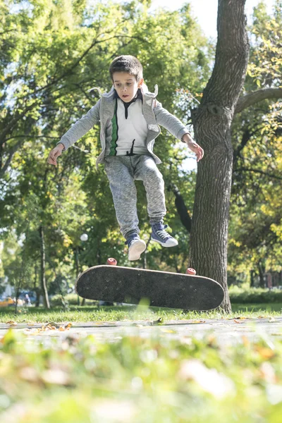 Boy with skateboard in park — Stock Photo, Image