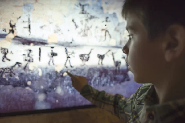 Child looks at ancient mural — Stock Photo, Image