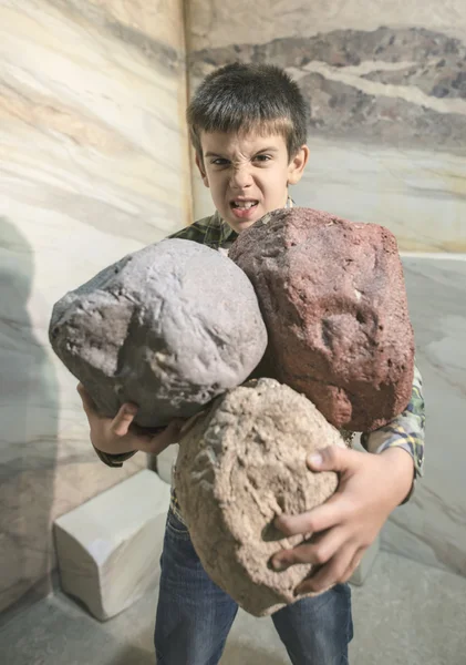 Un enfant fort tient des pierres lourdes — Photo