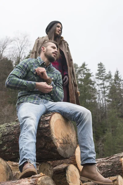 Žena a muž na dřevo protokoly — Stock fotografie