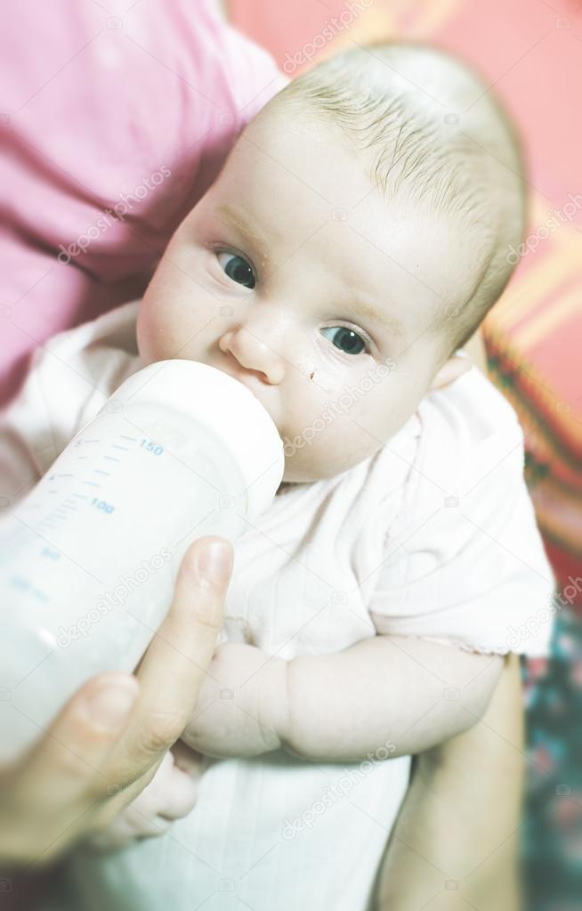 Baby sucks on bottle