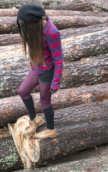 Donna su tronchi di legno — Foto Stock