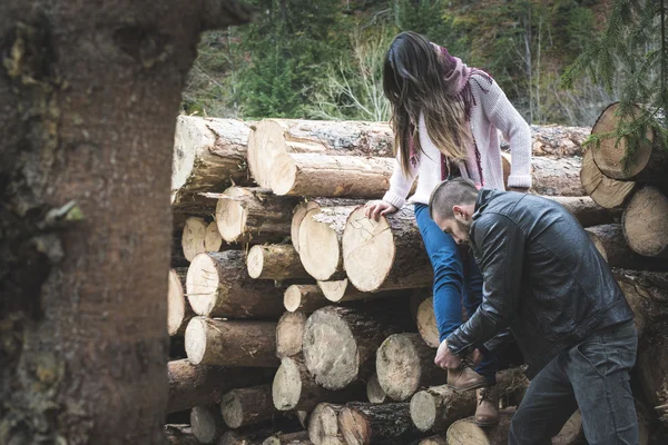 Donna e uomo su tronchi di legno — Foto Stock