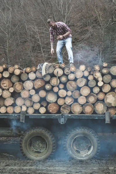 Man on vintage truck with logs — Stock Photo, Image