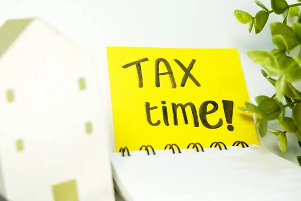 TAX TIME reminder with notebook and coins Tax season deadline and business concepts stock photo digitally created