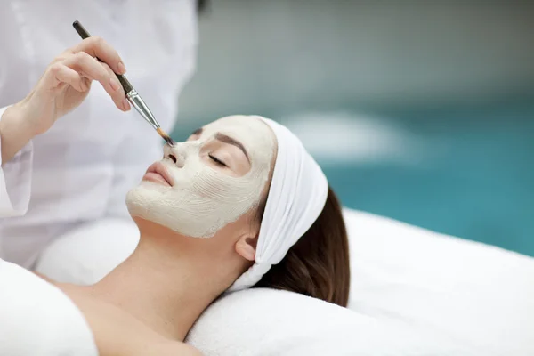 Portrait de belle fille avec une serviette sur la tête en appliquant un masque facial — Photo