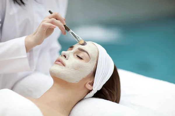 Retrato de una hermosa chica con una toalla en la cabeza aplicando mascarilla facial —  Fotos de Stock