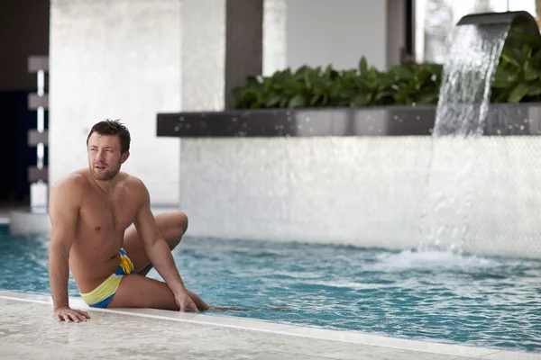 Muž pózuje v bazénu — Stock fotografie