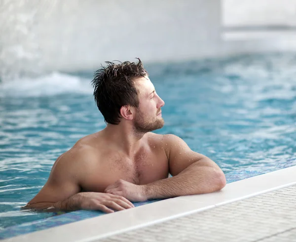 Yüzme Havuzu kenarında eğilerek adam — Stok fotoğraf