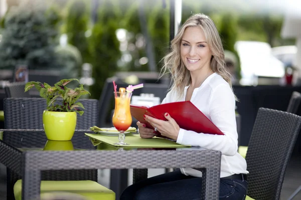 Vrouw aan een tafel in een café — Stockfoto