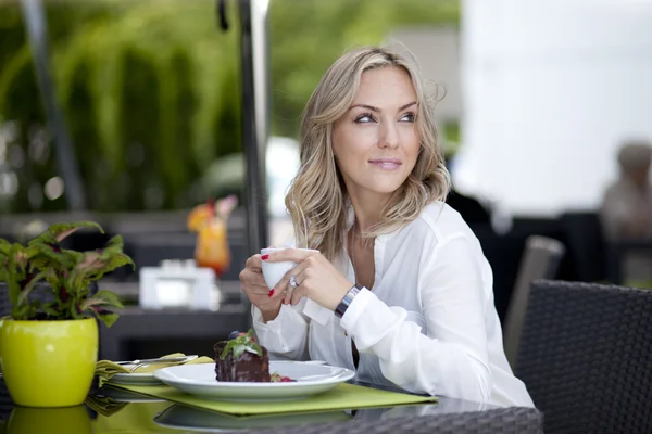 Woman at a table in a cafe — Stock Photo, Image