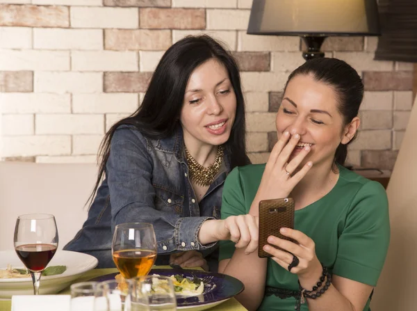 Duas mulheres usando um telefone inteligente — Fotografia de Stock