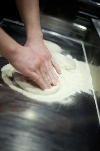 Le mani di uomo impastano la pasta — Foto Stock