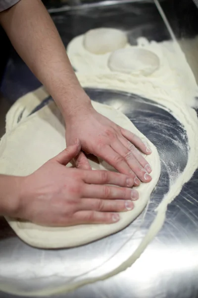 Мужские руки месят тесто — стоковое фото