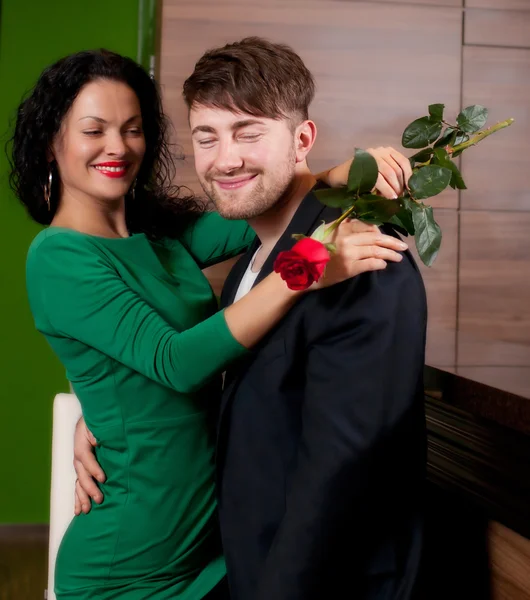 Homem com uma flor em uma mão e a menina perfeita no café — Fotografia de Stock