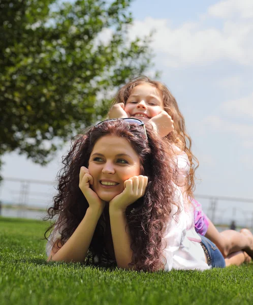 Giovane madre e figlia sdraiata sull'erba — Foto Stock