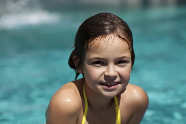 Meisje kind in blauwe water van het zwembad — Stockfoto