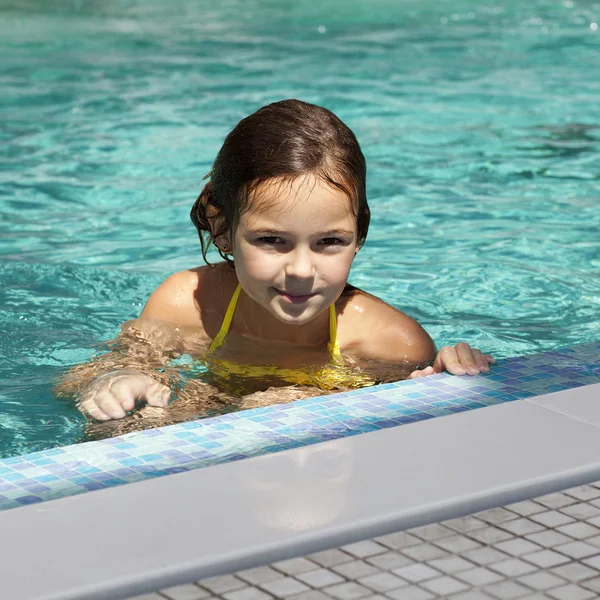 Meisje kind in blauwe water van het zwembad — Stockfoto