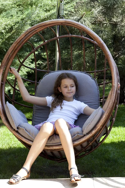 Muotokuva nuori tyttö istuu paju tuoli — kuvapankkivalokuva