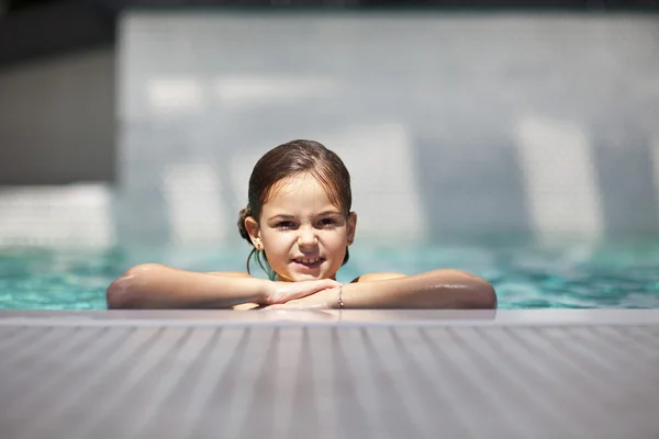 Meisje kind in blauwe water van het zwembad — Stockfoto