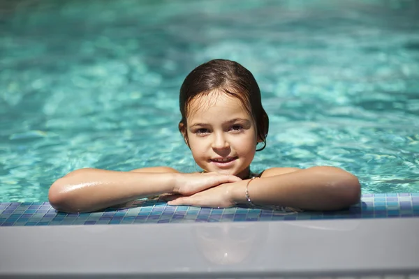 Девочка в голубой воде бассейна — стоковое фото