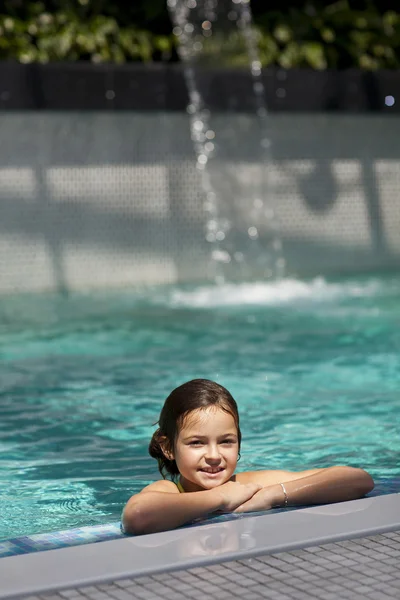 Meisje kind in blauwe water van het zwembad — Stockfoto