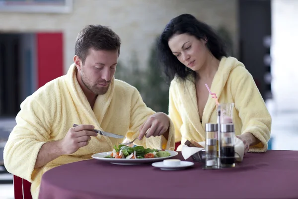 Linda pareja en albornoces desayunando juntos en el hotel — Foto de Stock