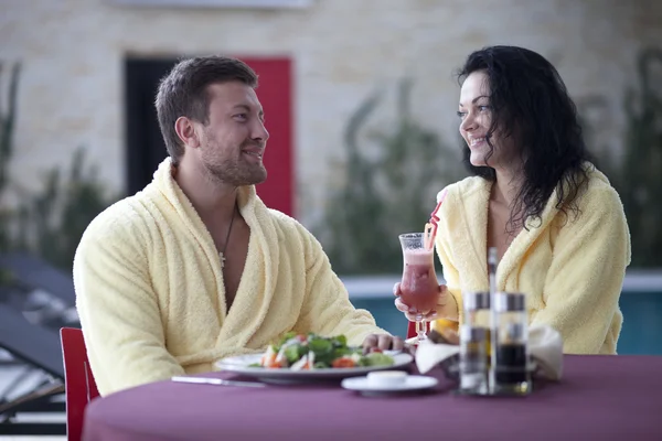 Cute couple in bathrobes having breakfast together at hotel — Stock Photo, Image