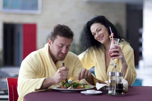 Linda pareja en albornoces desayunando juntos en el hotel —  Fotos de Stock