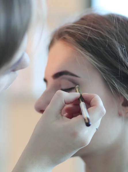 Unga makeup master tittar på kvinnans makeup i salong — Stockfoto