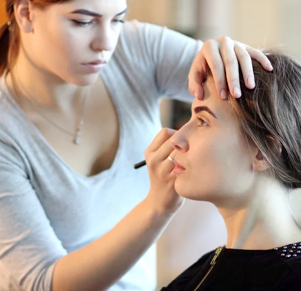 Artista de maquillaje profesional haciendo maquillaje modelo glamour en el trabajo —  Fotos de Stock