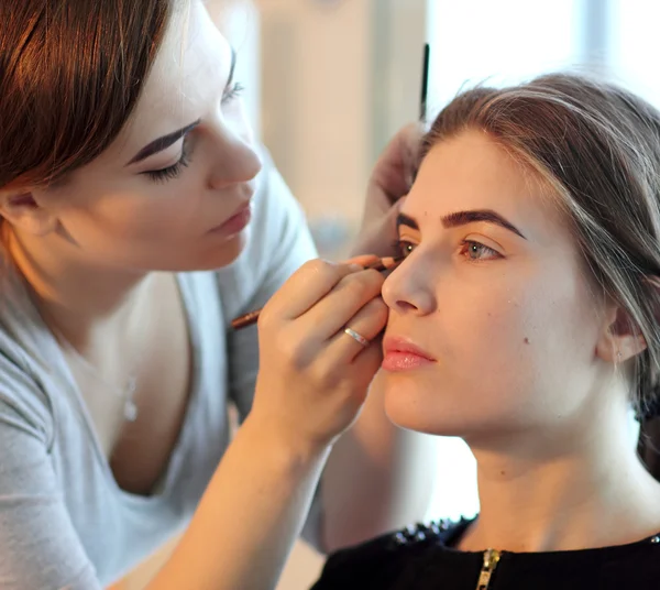Artista de maquillaje profesional haciendo maquillaje modelo glamour en el trabajo —  Fotos de Stock