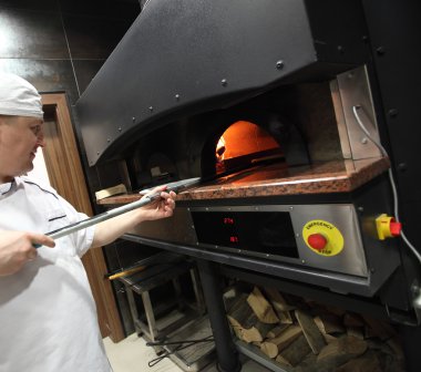 Beyaz üniformalı mutfak Pizza'da yapma Şef baker. Ellerini üstüne odaklanmak