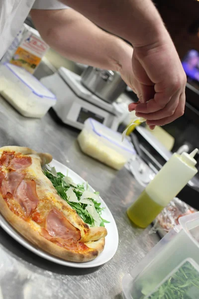 Chef padeiro em uniforme branco fazendo pizza na cozinha.Concentre-se nas mãos — Fotografia de Stock