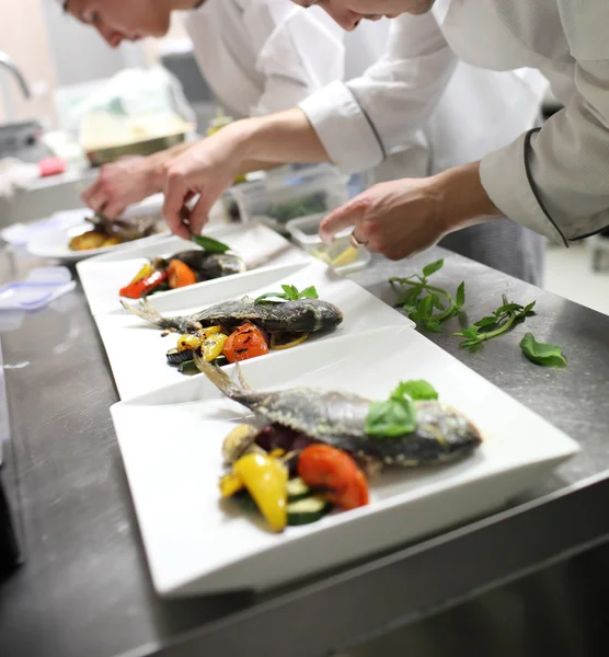 Chefs ocupados no trabalho na cozinha do restaurante — Fotografia de Stock