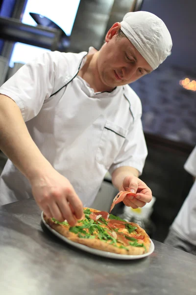 Chef-kok baker in witte uniform maken pizza in kitchen. — Stockfoto