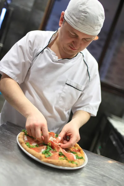 Chef padeiro em uniforme branco fazendo pizza na cozinha . — Fotografia de Stock