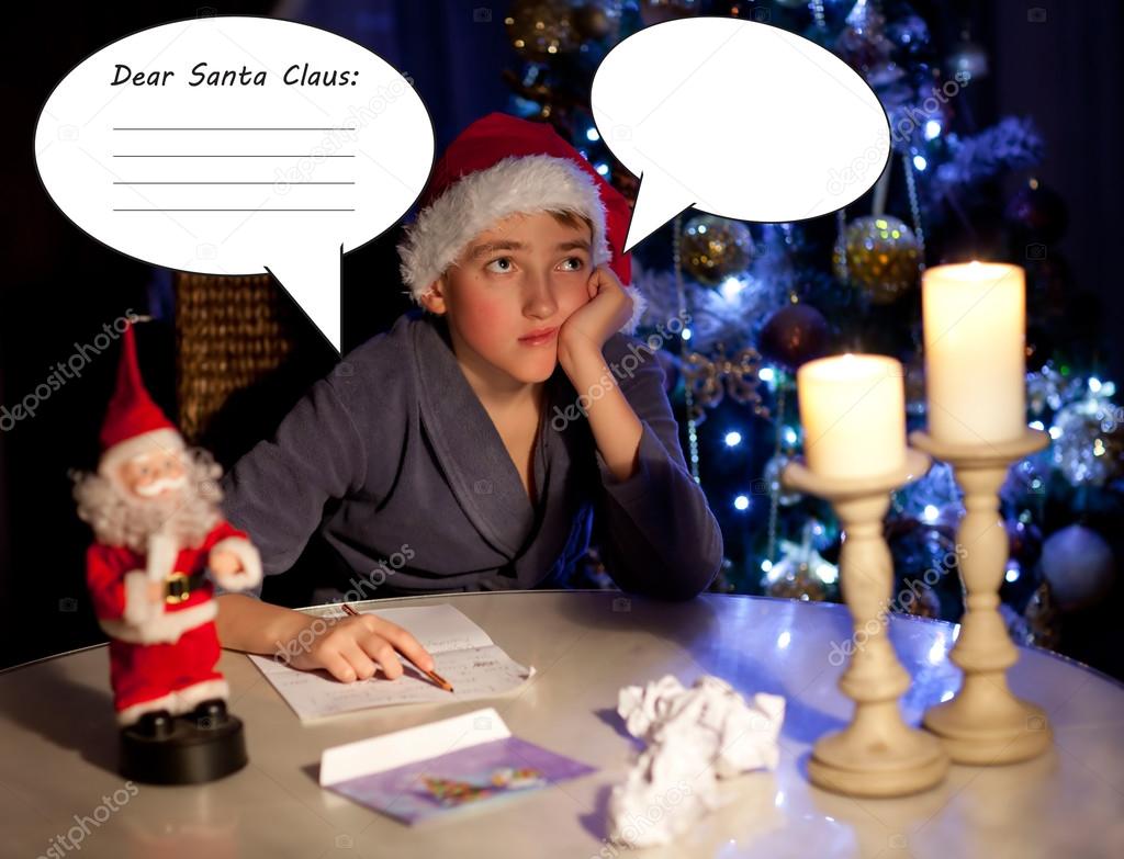small child writes the letter to Santa.Christmas background.