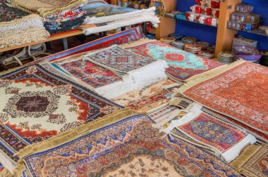 Geleneksel, renkli halılar ve halılar Türk pazarında veya dükkanında satışta karmaşık desenlere sahipler..