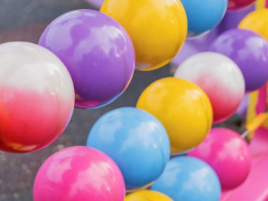 Neşeli, parlak bir yüzeye sahip renkli plastik topların yakın çekimi, güneşli bir günde bir çocuk oyun alanında oyuncu bir bariyer ya da dekorasyon olarak kullanılır. Çocuk eğlencesi için açık hava etkinliğinin bir parçası.