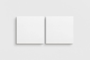 Tuvalin 1: 1 karesi. İki kare tuval seti. Temiz, modern, minimalist, parlak galeri duvarı maketi, beyaz bir duvarda 2 adet tuval..